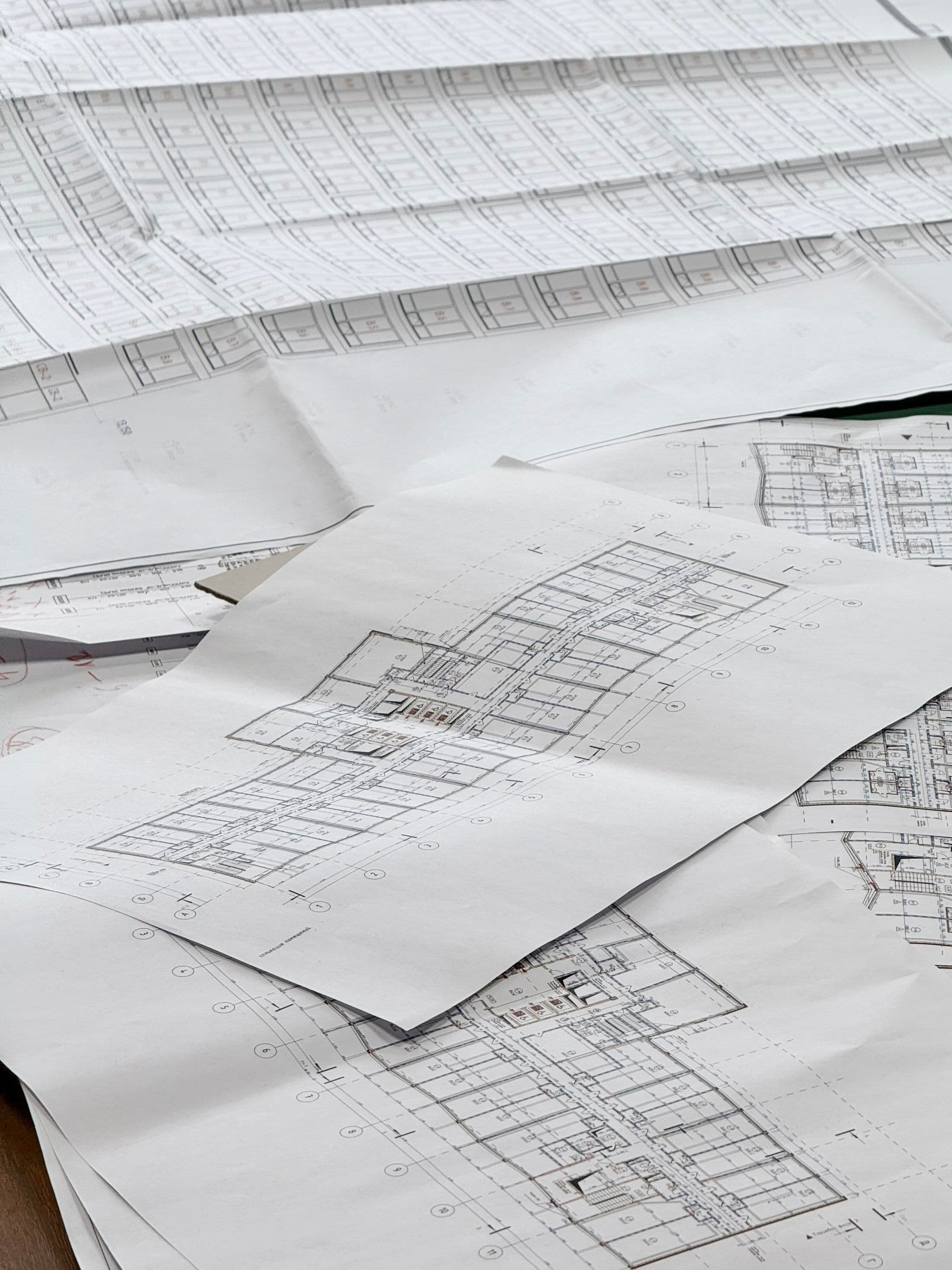Detailed architectural drawings arranged across a professional work surface